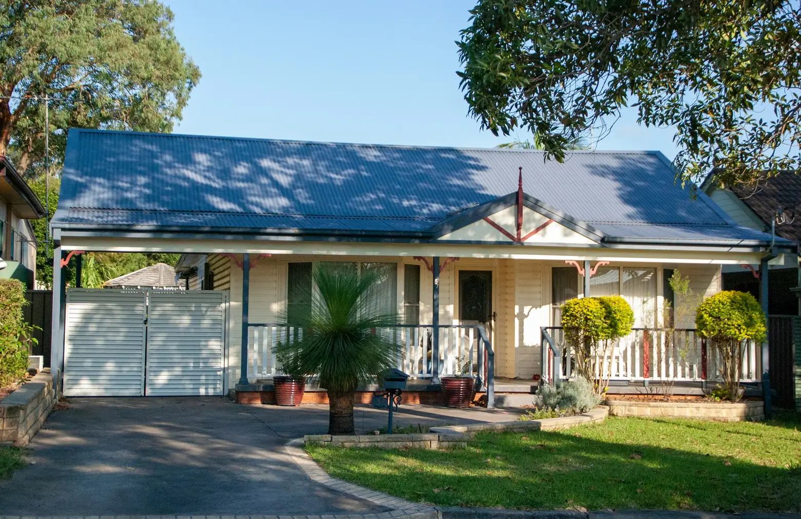 Single-storey house with a blue roof and front garden
