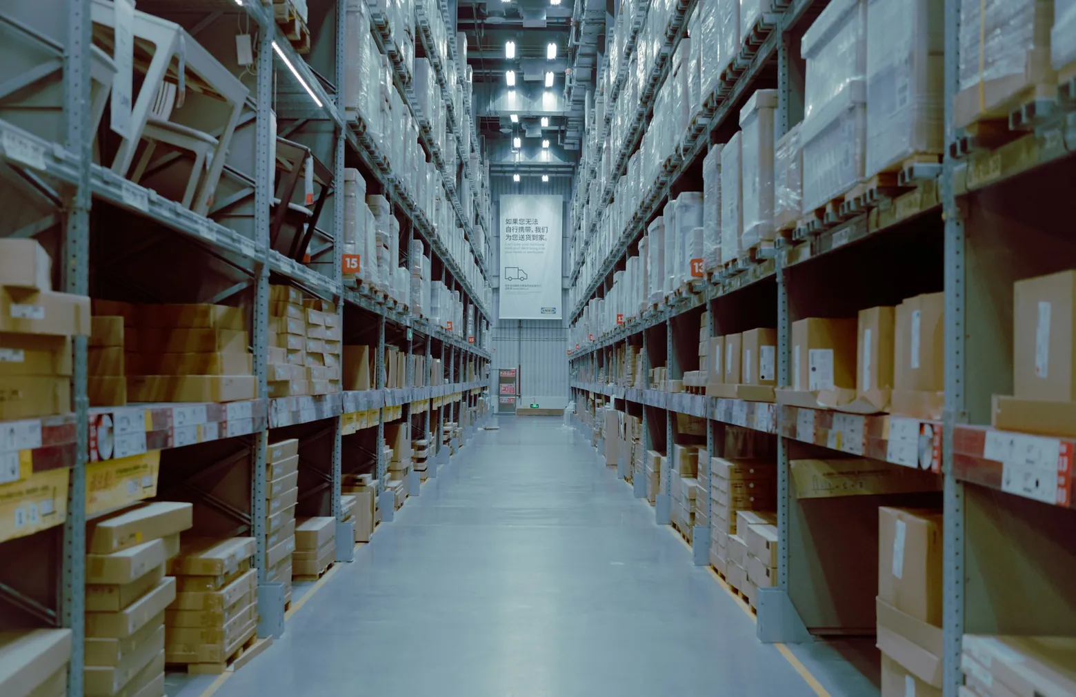 Long warehouse aisle lined with stocked shelving