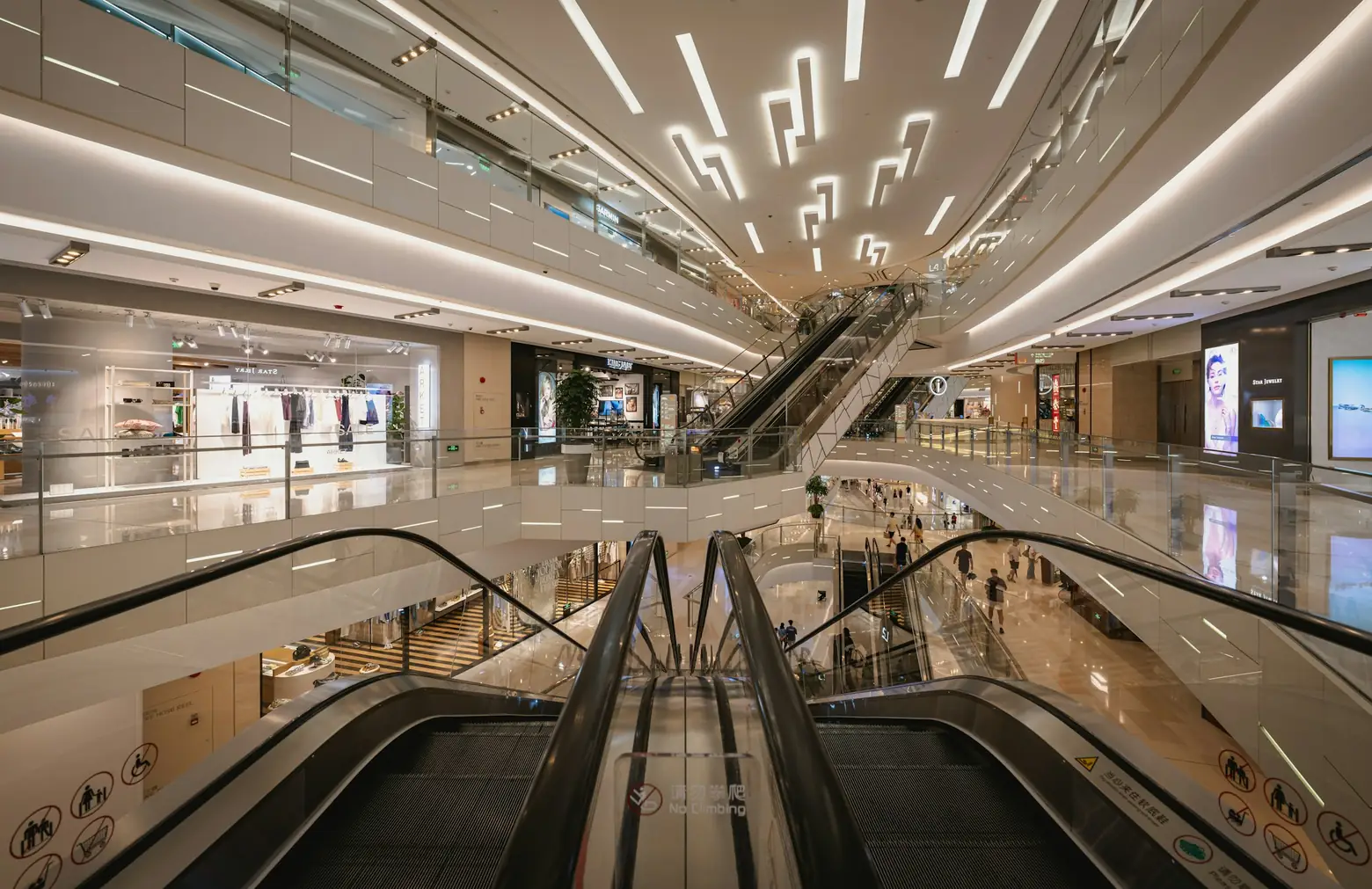 Shopping mall atrium with escalators and storefronts