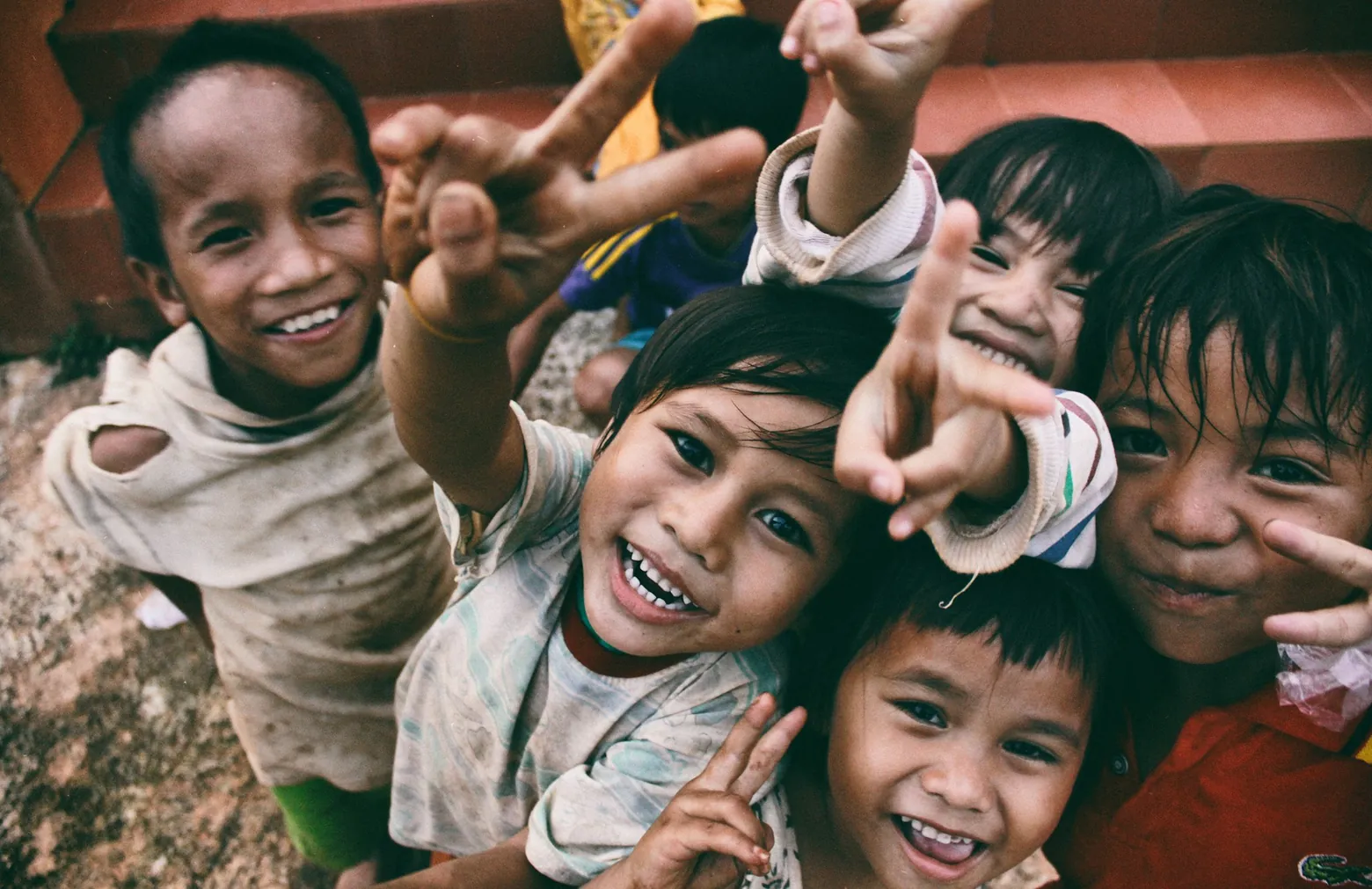 Group of smiling children making peace signs